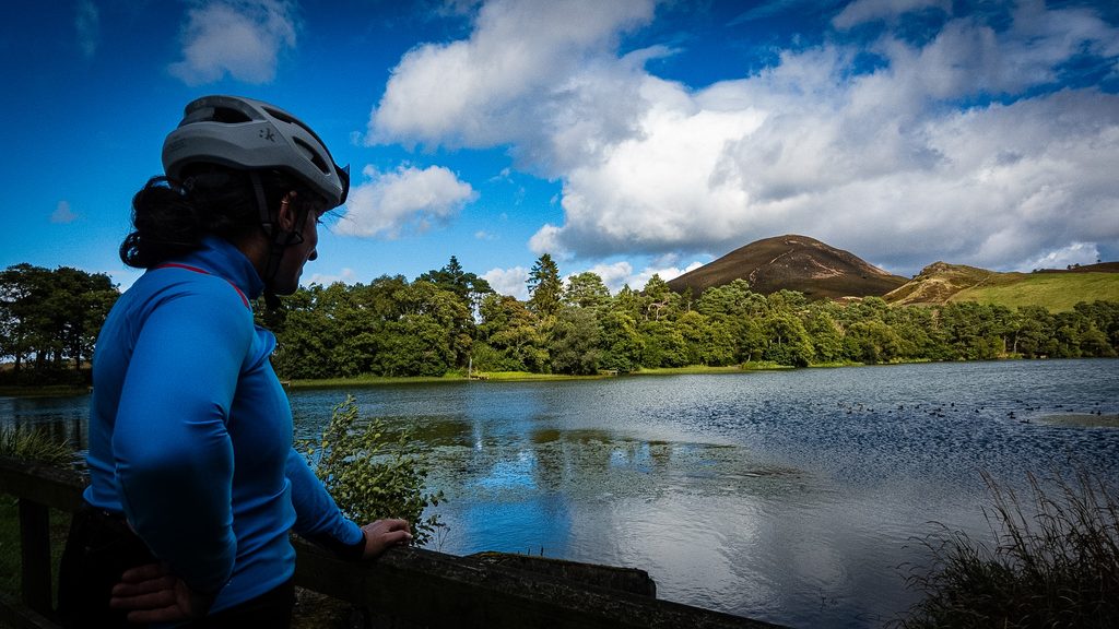 Fietser kijkt uit over Bowden Loch met een van de Eildon Hills erachter
