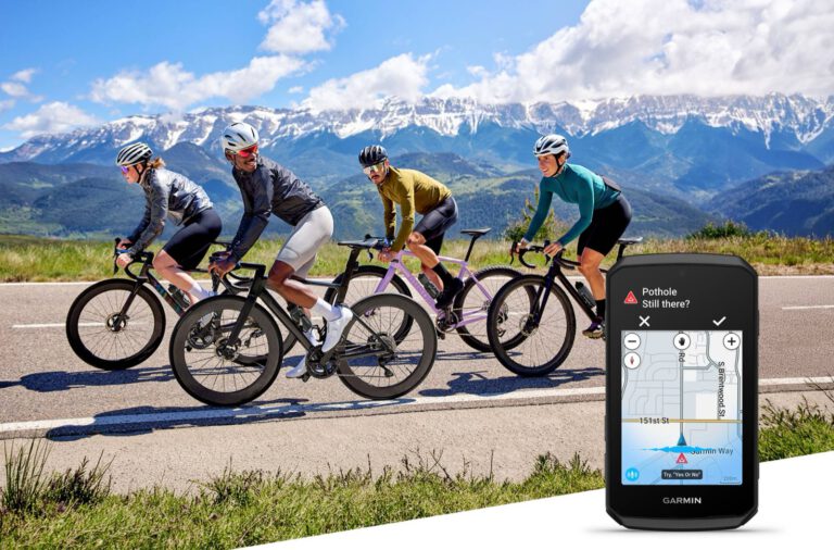 Four cyclists are riding on a mountain road with snow-covered peaks, with a Garmin Edge 1060 next to them showing a notification about a pothole in the road